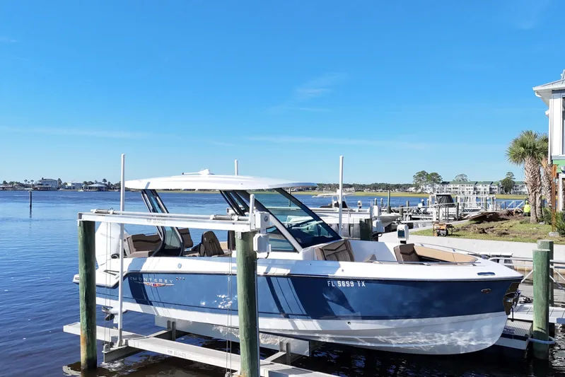  Yacht Photos Pics 2025 Monterey Elite 27 OB boat docked by a scenic waterfront.