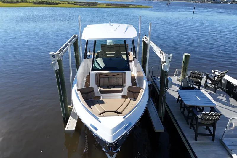  Yacht Photos Pics 2025 Monterey Elite 27 OB boat docked by a waterfront deck.