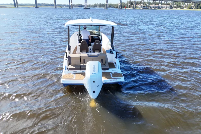  Yacht Photos Pics 2025 Monterey Elite 27 OB boat cruising on a sunny day, rear view.