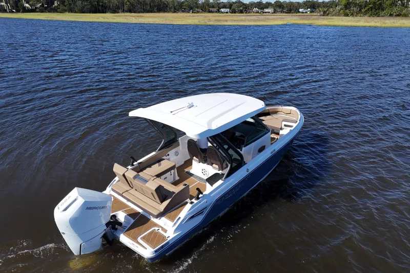  Yacht Photos Pics 2025 Monterey Elite 27 OB boat cruising on a serene lake.