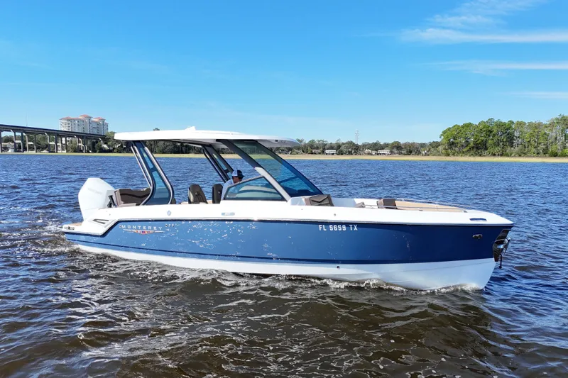  Yacht Photos Pics 2025 Monterey Elite 27 OB boat cruising on a sunny day, blue water and clear sky.