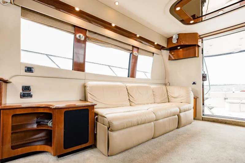 Sonshine Yacht Photos Pics Luxurious interior of 2004 Carver 56 Voyager yacht with beige leather sofa and wooden accents.