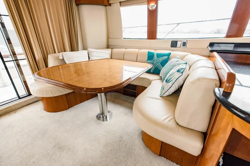Sonshine Yacht Photos Pics Luxurious interior of 2004 Carver 56 Voyager yacht with elegant seating and wooden table.