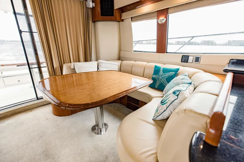 Sonshine Yacht Photos Pics Luxurious interior of 2004 Carver 56 Voyager yacht with elegant seating and wooden table.