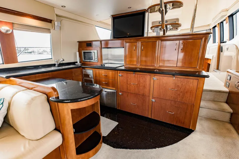 Sonshine Yacht Photos Pics Luxurious interior of 2004 Carver 56 Voyager yacht with modern kitchen and elegant wood cabinetry.