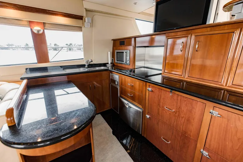 Sonshine Yacht Photos Pics Luxurious kitchen interior of 2004 Carver 56 Voyager yacht with wood cabinetry and modern appliances.