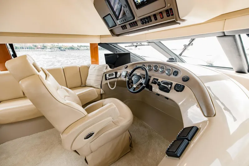 Sonshine Yacht Photos Pics Luxurious helm of 2004 Carver 56 Voyager yacht with beige leather seating and advanced controls.