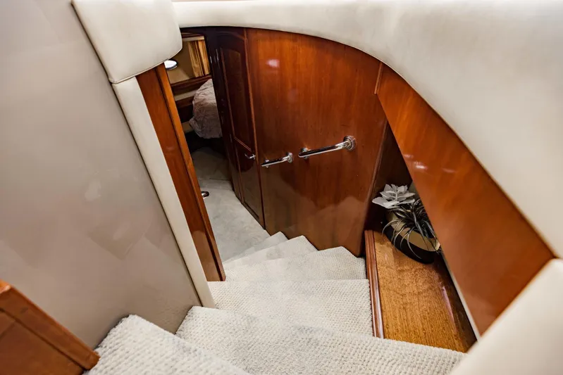 Sonshine Yacht Photos Pics Staircase inside 2004 Carver 56 Voyager yacht, featuring wooden paneling and carpeted steps.
