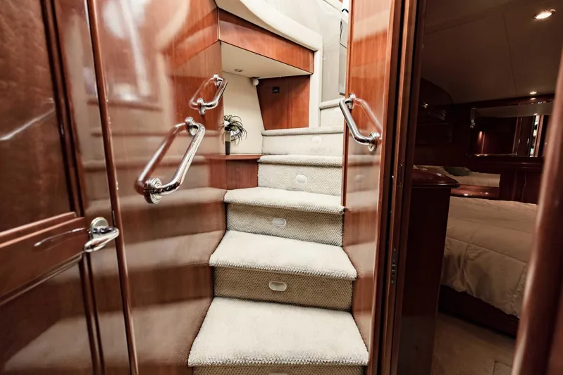 Sonshine Yacht Photos Pics Interior staircase of 2004 Carver 56 Voyager yacht with carpeted steps and wooden paneling.