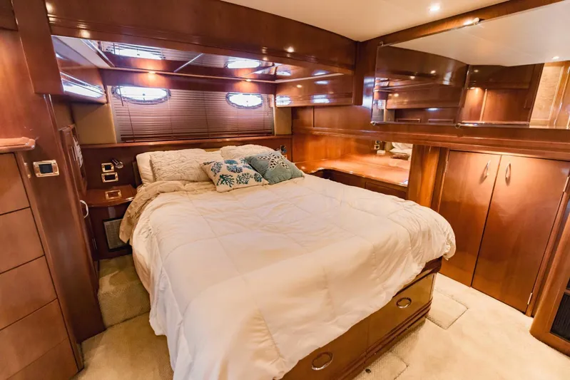Sonshine Yacht Photos Pics Luxurious bedroom interior of 2004 Carver 56 Voyager yacht with wood paneling and cozy bedding.