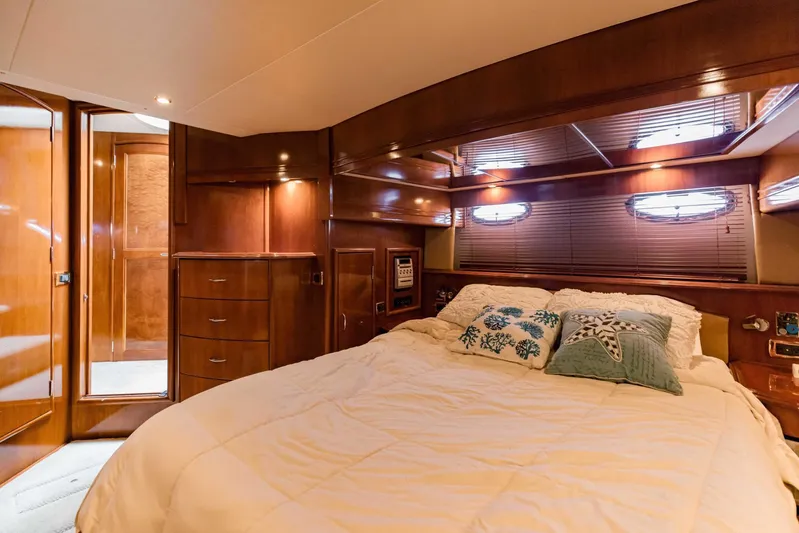 Sonshine Yacht Photos Pics Luxurious bedroom interior of 2004 Carver 56 Voyager yacht with wood paneling and cozy bedding.