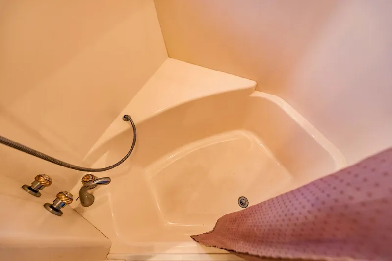 Sonshine Yacht Photos Pics Shower area in 2004 Carver 56 Voyager yacht with beige interior and purple curtain.