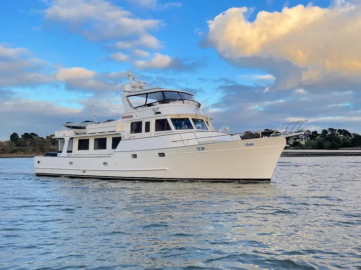 Perseus Yacht Photos Pics Luxury 2004 Fleming 75 yacht cruising on calm waters under a partly cloudy sky.