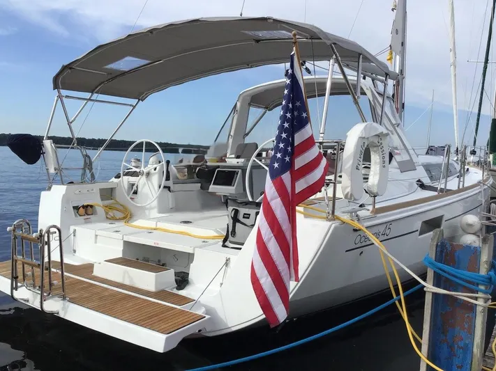Private Sessions Yacht Photos Pics 2018 Beneteau Oceanis 45 sailboat docked, featuring American flag and spacious cockpit.