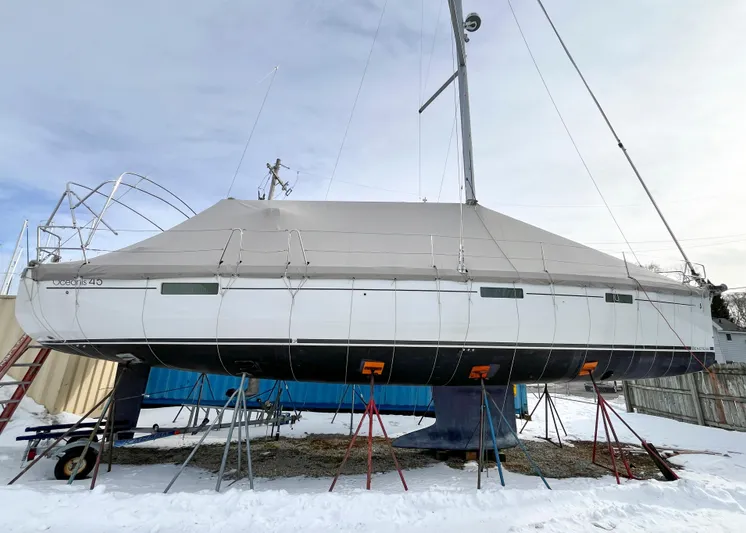 Private Sessions Yacht Photos Pics 2018 Beneteau Oceanis 45 sailboat covered and elevated on stands in a snowy yard.