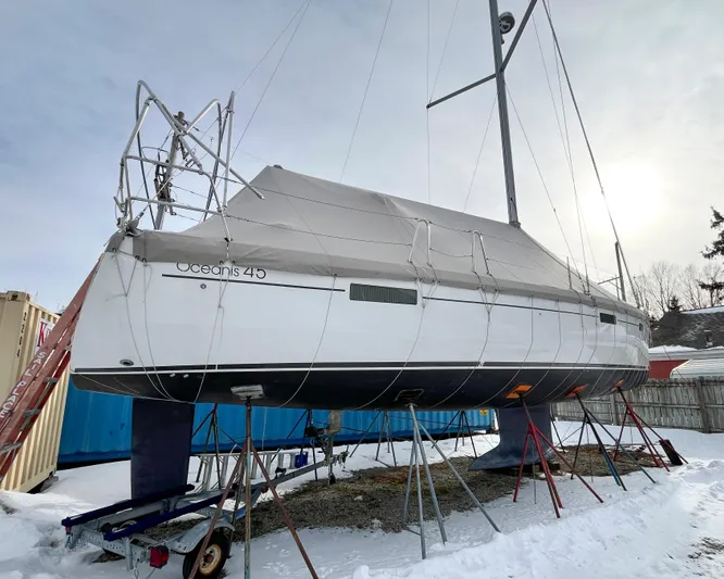 Private Sessions Yacht Photos Pics 2018 Beneteau Oceanis 45 sailboat on stands, covered, in snowy yard.