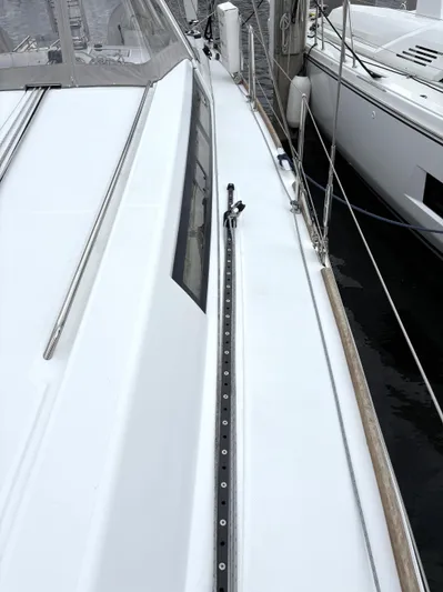 Private Sessions Yacht Photos Pics Beneteau Oceanis 45 sailboat deck, 2018 model, docked alongside another vessel.