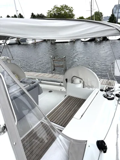 Private Sessions Yacht Photos Pics 2018 Beneteau Oceanis 45 sailboat cockpit with teak flooring, docked by the water.