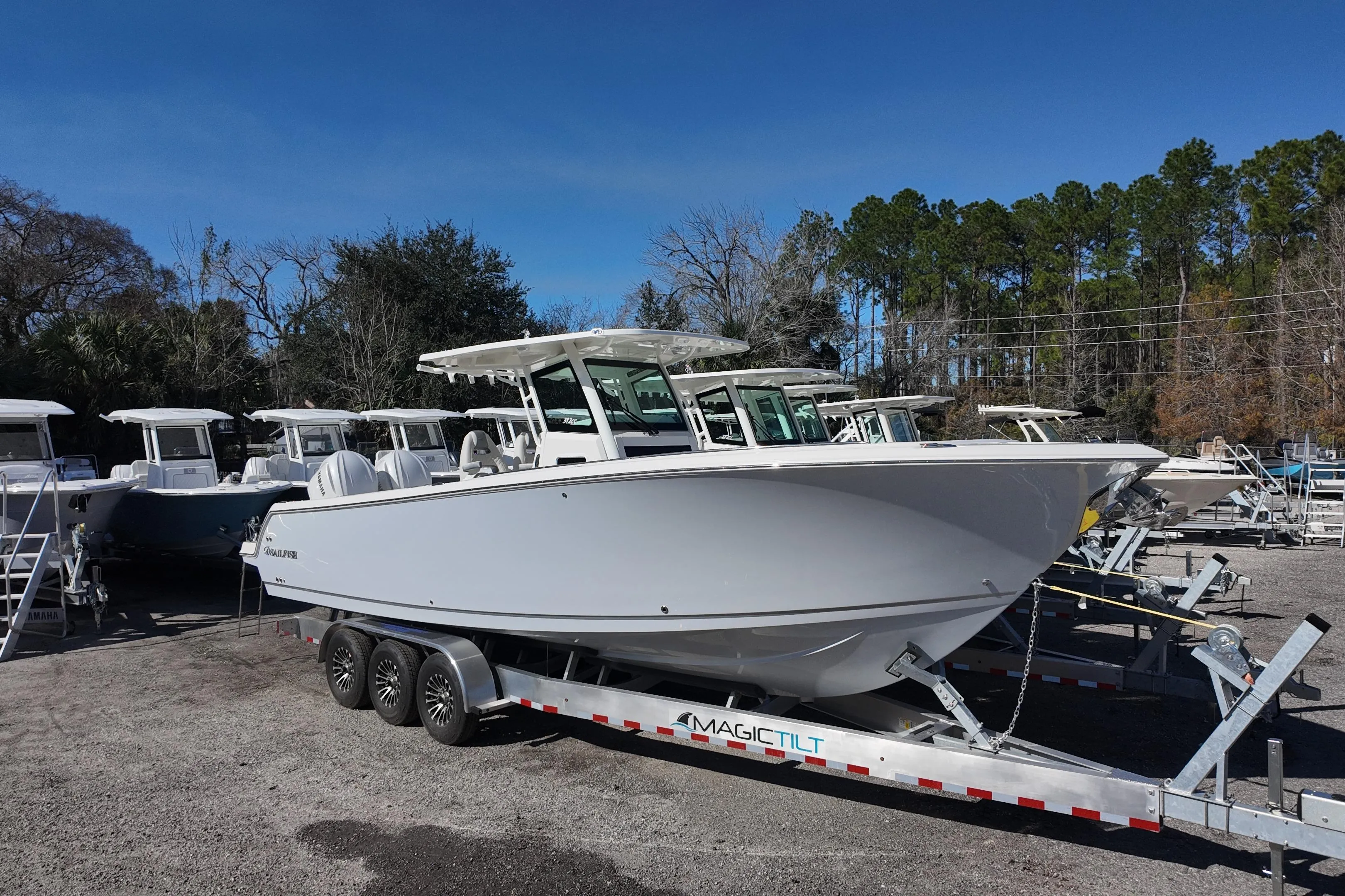 2026 Sailfish 312 CC boat on trailer, parked outdoors under clear blue sky.