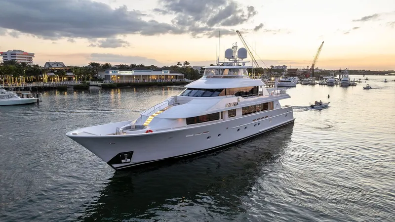 Antares Yacht Photos Pics Luxury 2008 Westport 130 yacht cruising at sunset near a coastal city.