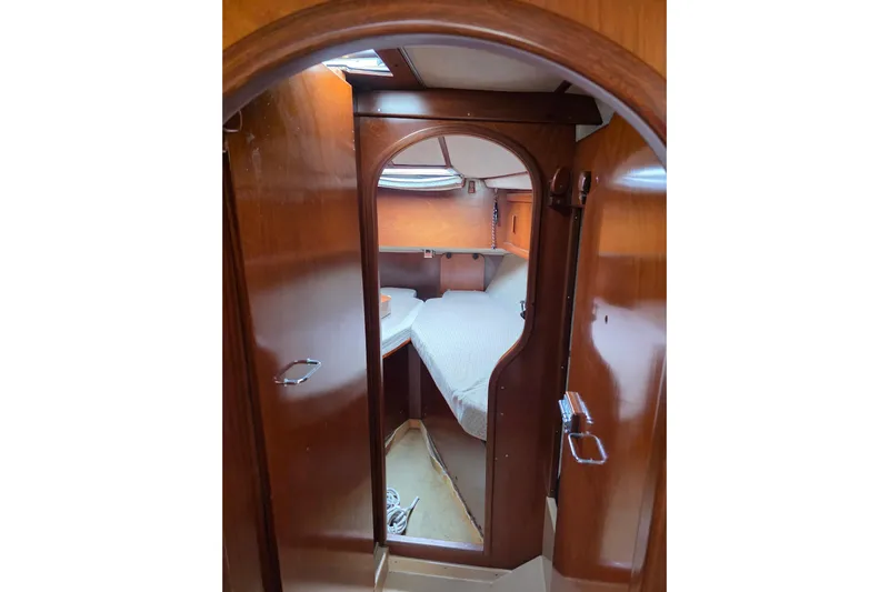 Fiasco Yacht Photos Pics Interior cabin of 1988 Amel Sharki sailboat with wooden finish and cozy bed.