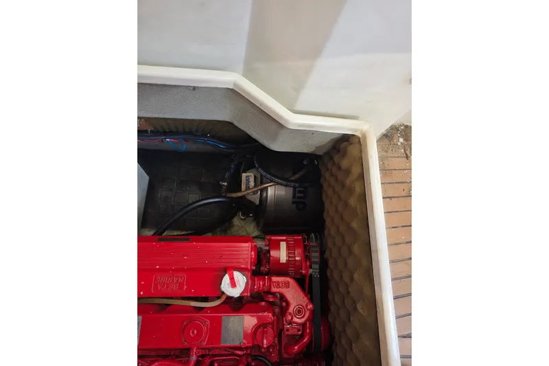 Fiasco Yacht Photos Pics Engine compartment of 1988 Amel Sharki sailboat with red machinery and insulation.