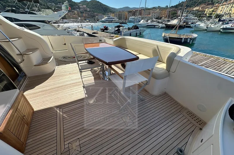  Yacht Photos Pics 2009 Azimut 68E yacht deck with seating and table, docked in a scenic marina.