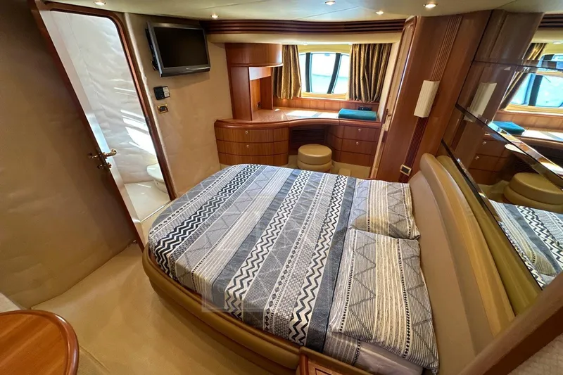  Yacht Photos Pics Luxurious bedroom interior of 2009 Azimut 68E yacht with elegant wood finishes.