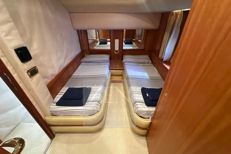  Yacht Photos Pics Twin cabin interior of 2009 Azimut 68E yacht with striped bedding and wooden finishes.
