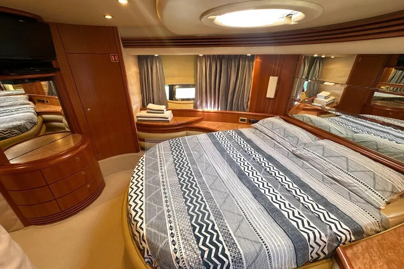  Yacht Photos Pics Luxurious bedroom interior of 2009 Azimut 68E yacht with elegant wood finishes.