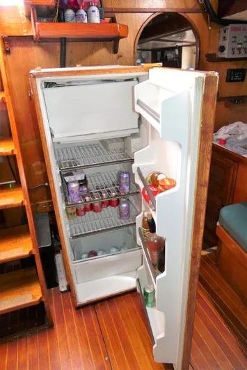 Spirit Yacht Photos Pics Open refrigerator inside a 1979 Roberts 54 boat, stocked with beverages and food.