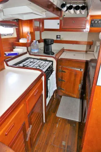Spirit Yacht Photos Pics 1979 Roberts 54 boat kitchen with wooden cabinets, stove, and countertop.