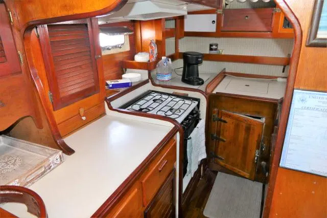 Spirit Yacht Photos Pics 1979 Roberts 54 boat kitchen with wooden cabinetry, stove, and countertop.