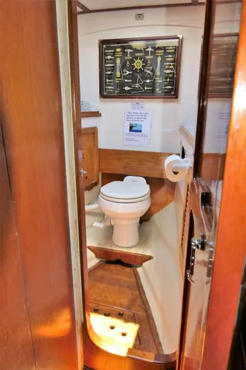 Spirit Yacht Photos Pics 1979 Roberts 54 boat bathroom with wooden interior and nautical decor.
