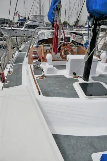 Spirit Yacht Photos Pics 1979 Roberts 54 sailboat docked at marina with blue sails and wooden steering wheel.