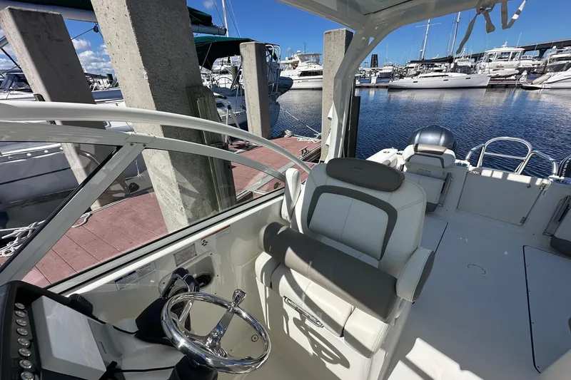 World Cat 296 Dc Yacht Photos Pics 2020 World Cat 296 DC boat interior at marina, featuring helm and seating area.