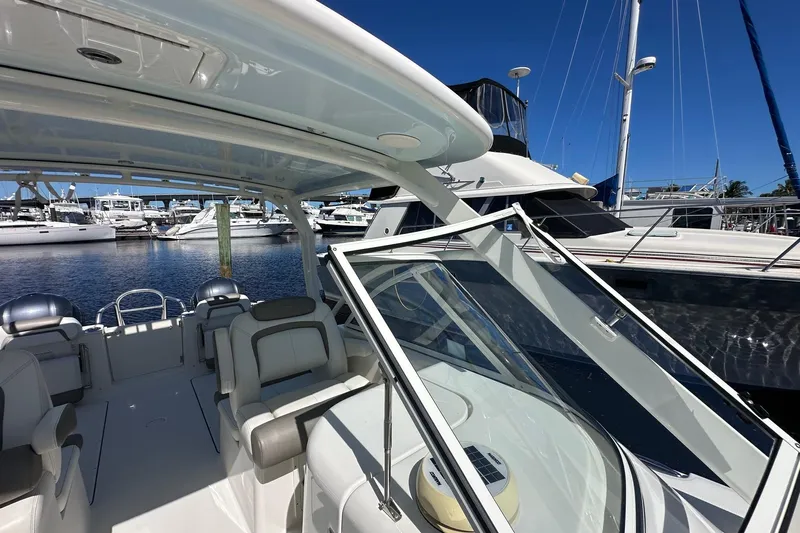 World Cat 296 Dc Yacht Photos Pics 2020 World Cat 296 DC boat interior at marina, showcasing seating and helm area.