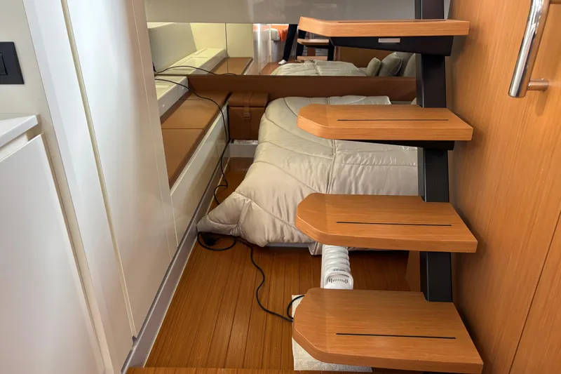  Yacht Photos Pics Interior of 2021 Bluegame BG42 yacht with wooden steps and cozy bedding.