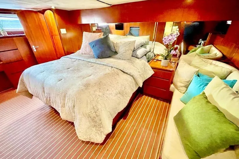 New Beginning Yacht Photos Pics Luxurious 1990 Cheoy Lee 75 yacht bedroom with cozy bedding and elegant wood finish.