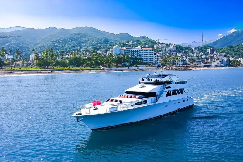 New Beginning Yacht Photos Pics Luxury 1990 Cheoy Lee 75 yacht cruising near scenic coastal cityscape.