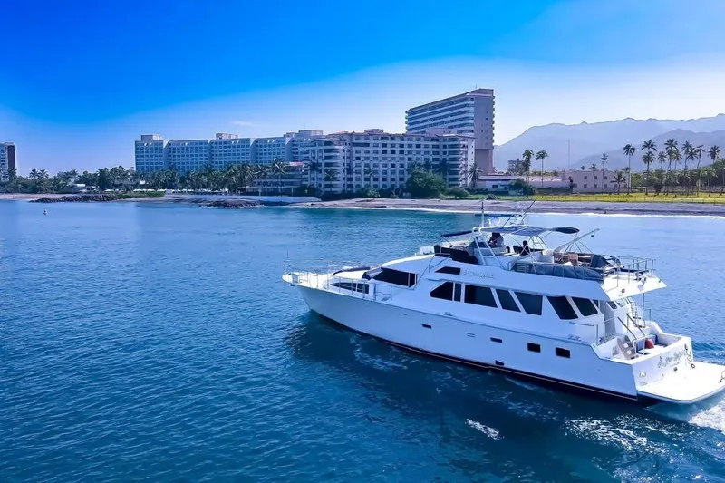 New Beginning Yacht Photos Pics Luxury 1990 Cheoy Lee 75 yacht cruising near coastal resort skyline.