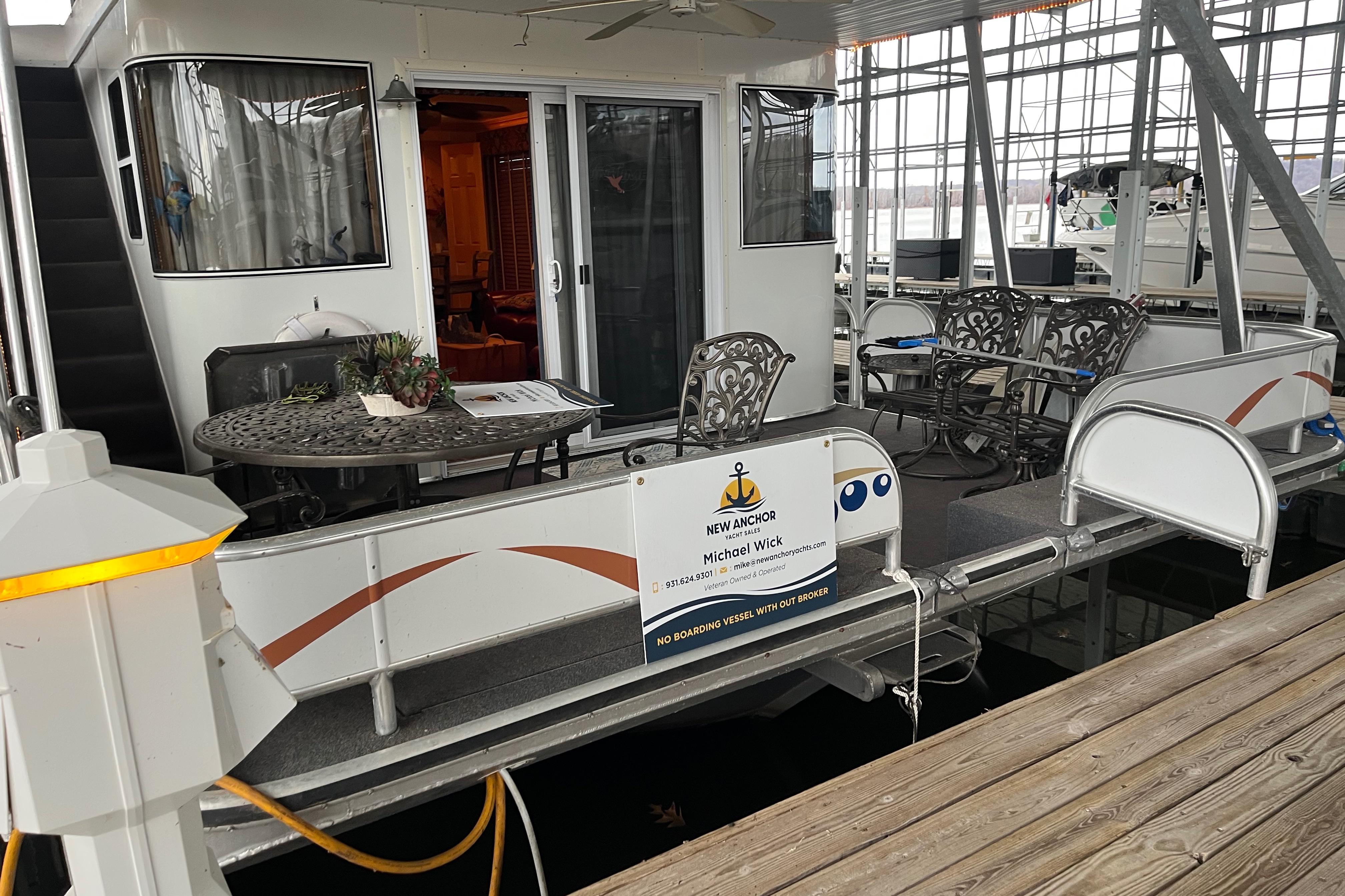 Houseboat docked with outdoor seating, Funtime 68x16 model, 2010.