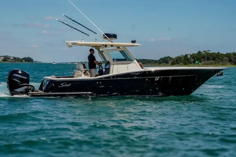  Yacht Photos Pics 2017 Scout 300 LXF boat cruising on clear blue water with fishing rods.