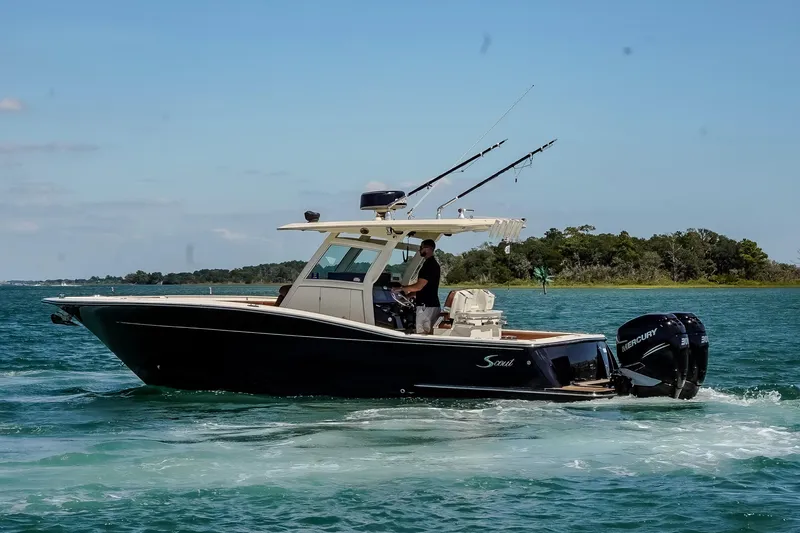  Yacht Photos Pics 2017 Scout 300 LXF boat cruising on clear blue water with fishing rods.