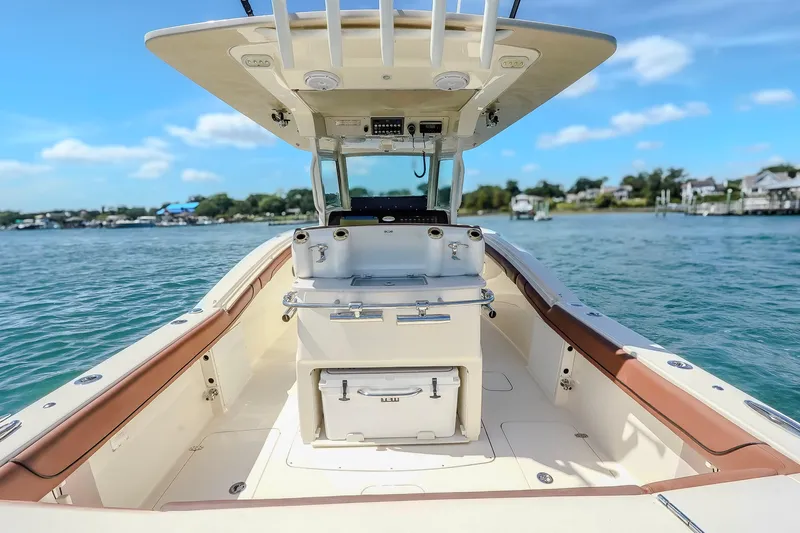  Yacht Photos Pics 2017 Scout 300 LXF boat interior with helm, on calm water under blue sky.