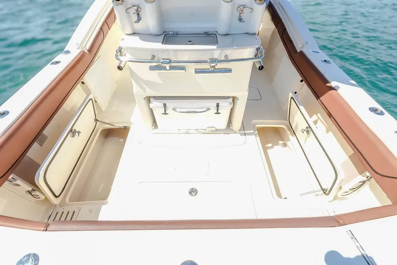  Yacht Photos Pics 2017 Scout 300 LXF boat interior with storage compartments and seating, on calm water.