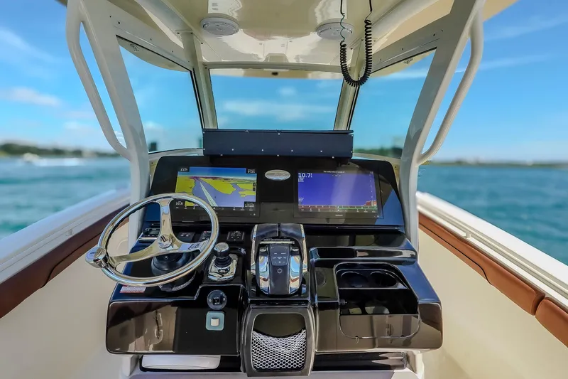  Yacht Photos Pics 2017 Scout 300 LXF boat dashboard with navigation screens and steering wheel.