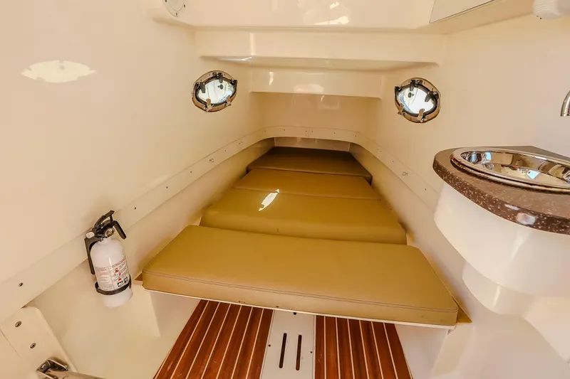  Yacht Photos Pics 2017 Scout 300 LXF cabin interior with cushioned seating, portholes, and a compact sink.