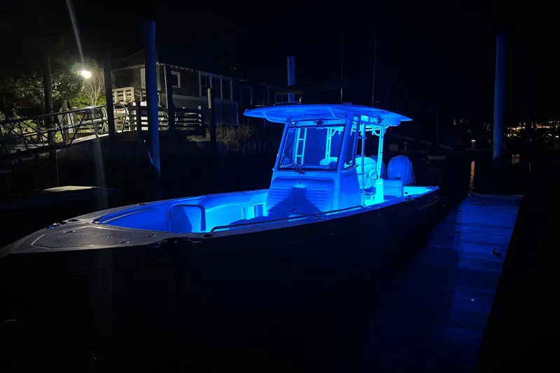 Let's Dance Yacht Photos Pics 2020 Edgewater 340CC boat illuminated with blue lights at night, docked in a marina.