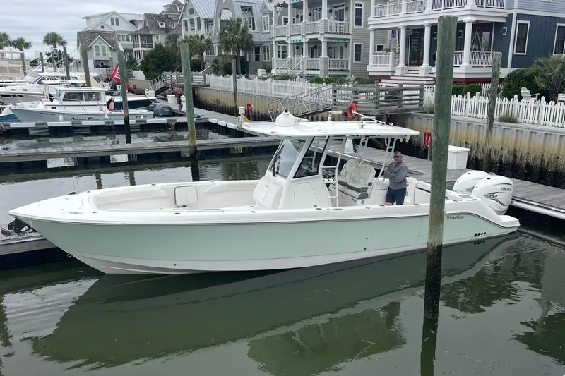 Let's Dance Yacht Photos Pics 2020 Edgewater 340CC boat docked in a marina with waterfront homes in the background.